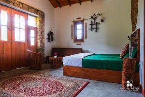 a bedroom with a bed and a door and a rug at Knuckles Retreat in Huluganga