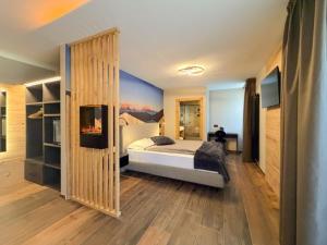 ein Schlafzimmer mit einem Bett und einer Wand mit einem Gemälde in der Unterkunft Hotel Fantelli in Folgarida + 105 Fotos