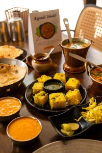 a table topped with plates of food and bowls of dips at Girivihar Holiday Club - Pure Veg in Lonavala