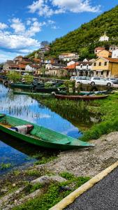 a group of boats sitting in the water near a town at Apartments Skadar Lake in Vranjina +3 photos