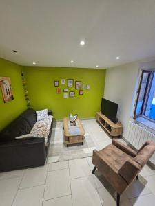 a living room with a couch and a tv at Ma p'tite maison in Fumay