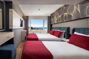 a hotel room with two beds with red pillows at Sultanahmet Nu Hotel in Istanbul