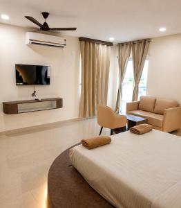 a bedroom with a bed and a couch and a tv at Maruthi inn hotel in Vijayawāda