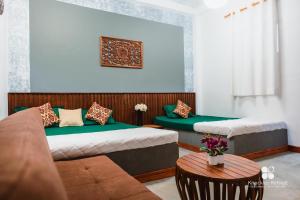 a room with two beds and a couch and a table at Knuckles Retreat in Huluganga