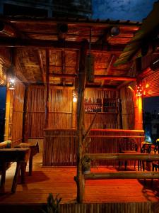 a restaurant with a wooden patio with benches and tables at Ostad Jahangir Resort in Cox's Bazar