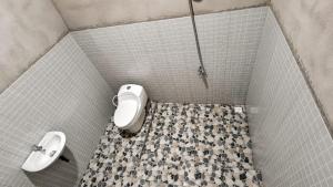 a bathroom with a toilet and a sink at Garden Cottage in Gili Gede