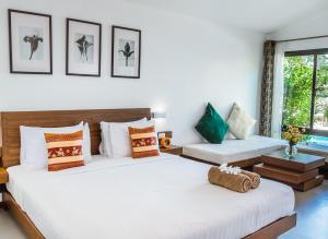 two beds in a room with two windows at Family House Zen Boutique Resort in Pai