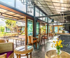 a restaurant with tables and chairs and windows at Family House Zen Boutique Resort in Pai