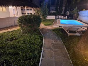 a backyard with a swimming pool and a grass yard at Lilo House in Watamu