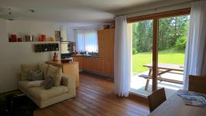 a living room with a couch and a sliding glass door at Splendida e soliva dimora con giardino in La Punt-Chamues-ch