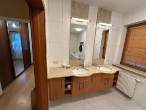 a bathroom with two sinks and a large mirror at Anna Maria in Łomianki
