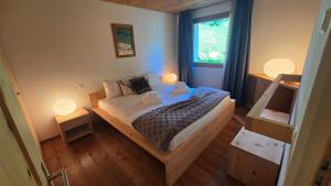 a bedroom with a bed with two lamps on it at Splendida e soliva dimora con giardino in La Punt-Chamues-ch