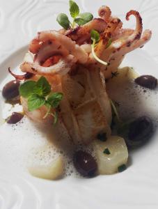 un plato de comida con camarones en un plato blanco en Le Grand Hotel, en Sète