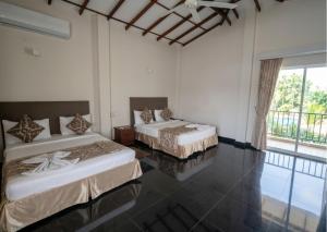 a bedroom with two beds and a large window at Nilakma Lagoon in Negombo +53 photos
