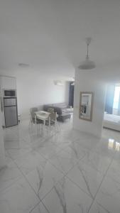 a white living room with a table and chairs at Eddy's Luxury Suites - Ilyonis in Shëngjin