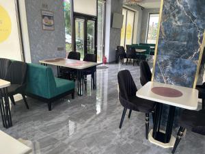 a restaurant with tables and chairs and a mirror at HIQ Hotel Home Inn Qusar in Qusar