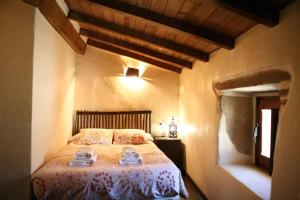 a bedroom with a bed in a room with wooden ceilings at Arribes del Duero casa rural Balneario, hotel rural Bermellar y Camino de Hierro in Bermellar +47 photos
