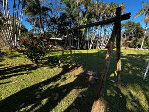 a wooden fence in a park with trees and grass at Chacara c piscina ampla em Pedro de toledo in Pedro de Toledo