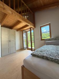 a bedroom with a bed and a large window at NaturZeit Melleck in Schneizlreuth