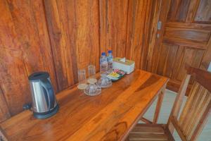 a wooden table in a room with a stove and drinks at Villa Kebun Pala in Borobudur