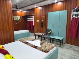 a hospital room with two beds and a chair at T & G Guest House in Patna +7 photos