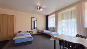 a room with two beds and a table and a window at Noclegi Słodki Sen 2 in Lublin