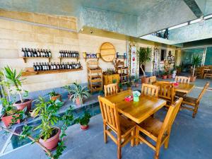 a restaurant with wooden tables and chairs and plants at Veradarc Hotel & Restaurant in Noratus