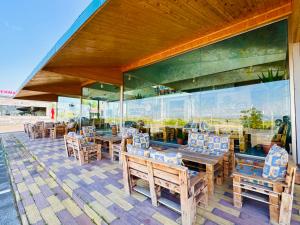 a restaurant with wooden tables and chairs in front of a building at Veradarc Hotel & Restaurant in Noratus