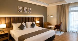 a hotel room with a large bed and a desk at Ras Hotel - Harar in Hārer +17 photos