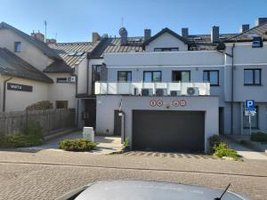 ein weißes Haus mit Garage in der Straße in der Unterkunft Centrum Marzeń in Suwałki