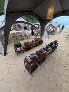 a group of tables and chairs on a beach with tents at camp asri in Bukittinggi +26 photos