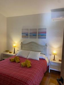 a bedroom with a bed with two yellow pillows on it at Finca Dos Vientos Tarifa in Tarifa