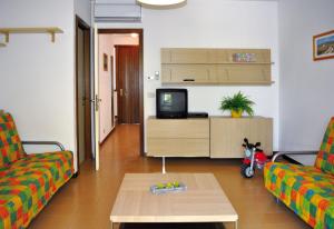 un soggiorno con 2 divani e una TV di Villaggio Dei Fiori a Bibione