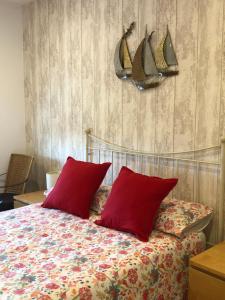 a bedroom with a bed with red pillows at Apartamento El Capricho in Cudillero