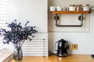a kitchen counter with a vase of flowers on a table at Boutique-Style Apartment in Heart of Brighton Lanes in Brighton & Hove