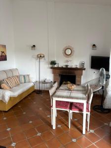 a living room with a couch and a table and a fireplace at Finca Dos Vientos Tarifa in Tarifa