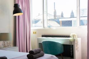 a bedroom with a bed and a desk and a window at Boutique-Style Apartment in Heart of Brighton Lanes in Brighton & Hove
