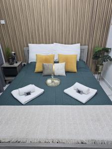 a bed with two white towels and a tray on it at Marble Coast Studio Apartment in Larnaca