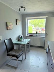 a kitchen with a table and a chair and a window at Ferienwohnung am Binnensee 2 in Heiligenhafen
