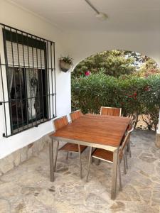a wooden table and chairs on a patio at Finca Dos Vientos Tarifa in Tarifa