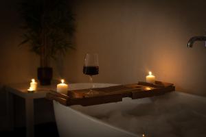 a glass of wine and candles in a bath tub at Boutique-Style Apartment in Heart of Brighton Lanes in Brighton & Hove +40 photos