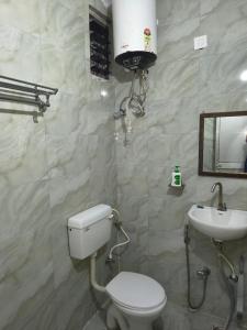 a bathroom with a toilet and a sink at T & G Guest House in Patna