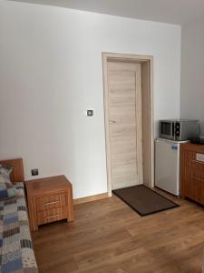 a room with a bed and a door with a microwave at Noclegi i Restauracja Gracja in Bełchatów