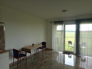 a dining room with a table and chairs and a window at Áporka vendégház in Áporka +7 photos