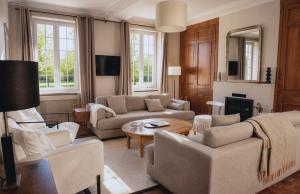 a living room with couches and a table at Clos de Gauville in Brétigny