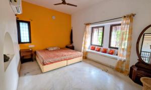 a bedroom with a bed and a window in it at Charming Stone Cottage in erstwhile grape gardens in Secunderabad