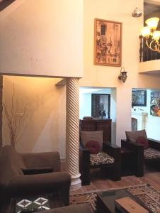 a living room with couches and a fireplace at Charming Stone Cottage in erstwhile grape gardens in Secunderabad