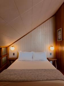 a bedroom with a large bed with two lamps at The Lark Inn & Kitchen in San Juan
