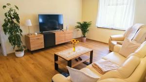 a living room with a couch and a tv at Ferienwohnung Talblick Wilthen in Wilthen