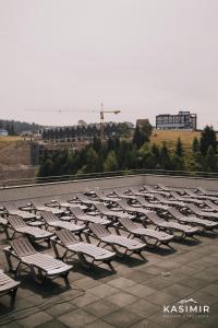 a row of white chairs sitting on top of a roof at Kasimir Hotel & SPA in Bukovel